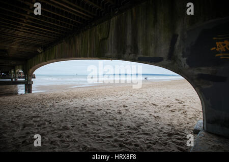 Beton Bögen unter Bournemouth Pier bei Ebbe an einem bewölkten Winter Tag in Dorset, England, UK. Stockfoto