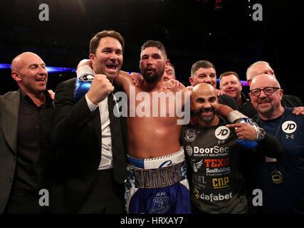 Tony Bellew feiert Sieg über David Haye neben Promoter Eddie Hearn (links) und Trainer Dave Coldwell (rechts) nach dem Schwergewichts-Wettbewerb in The O2. Stockfoto