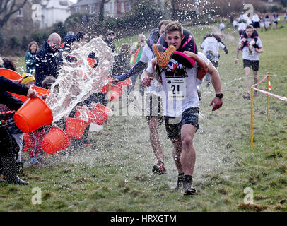 Jack Mckendrick von North Wales, mit seinem Partner Kirsty Jones gewinnt die 10. UK Frau tragen Race in Dorking, Surrey. Stockfoto