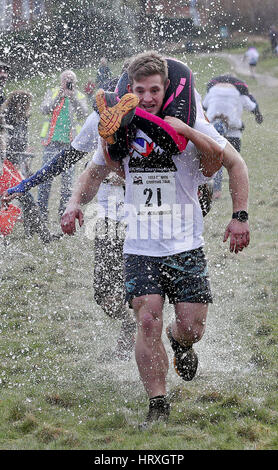 Jack Mckendrick von North Wales, mit seinem Partner Kirsty Jones gewinnt die 10. UK Frau tragen Race in Dorking, Surrey. Stockfoto