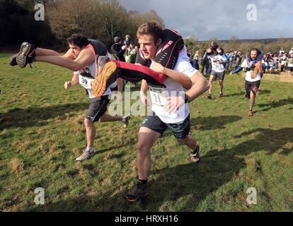 Jack Mckendrick von North Wales, mit seinem partner Kirsty Jones (rechts) auf seinem Weg zum Sieg beim 10. UK Frau tragen Rennen in Dorking, Surrey. Stockfoto