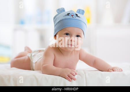 Fünf Monate Baby junge weared in lustigen Hut liegend auf einer Decke