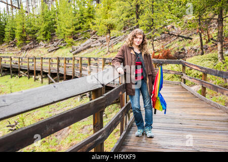 Frau stehend am Boardwalk in Mud Volcano Gegend im Yellowstone National Park mit Regenschirm Stockfoto