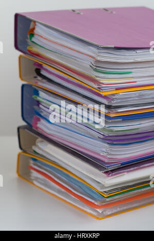 Verschiedene bunte Ordner mit Dokumenten gestapelt in einem Haufen auf dem Tisch. Close-up Stockfoto