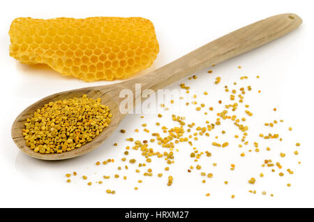 Blütenpollen in einem Holzlöffel und eine Honigwabe auf weißem Hintergrund Stockfoto