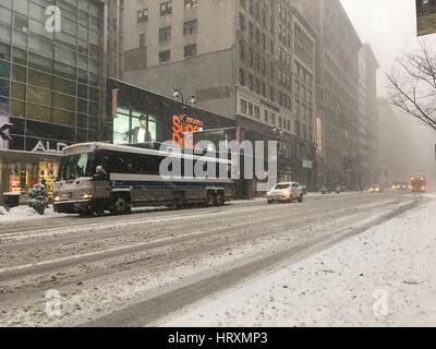 NEW YORK CITY - 9. Februar 2017: Autos und eine Stadt passieren langsam senken 34th Street in Midtown Manhattan in einem schlechten Schneesturm in New York. Schnee bedeckt Stockfoto