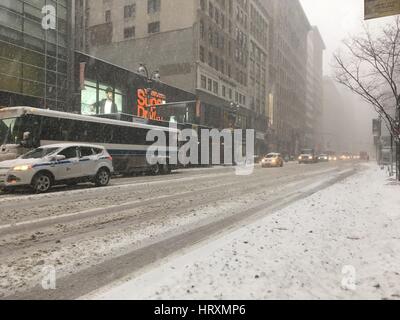 NEW YORK CITY - 9. Februar 2017: Stadtbus und morgen Verkehr langsam Fahrt auf Schnee verpackt 34th Street in Midtown Manhattan vor dem Super Dry Stockfoto