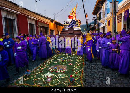 Antigua, Guatemala - 16. April 2014: Mann trägt lila Roben, mit einem Schwimmer (Anda) während dem Osterfest in der Karwoche in Antigua Stockfoto