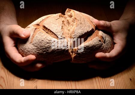 Brotbrechen auf einem Holztisch dunklen Hintergrund Stockfoto