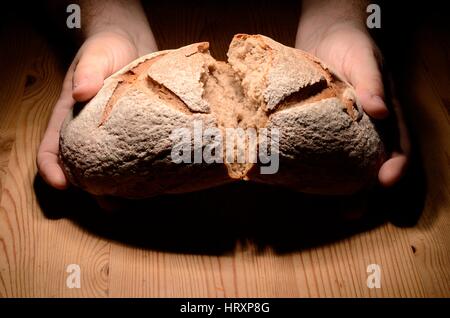 Brotbrechen auf einem Holztisch dunklen Hintergrund Stockfoto