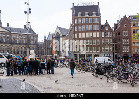 Dam Platz in Amsterdam, Niederlande, mit vielen Touristen und Fahrräder an einem Sommertag Stockfoto