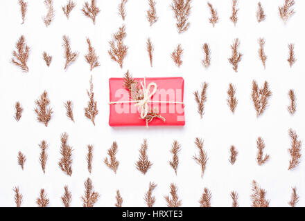 Goldene Äste in eine Zeile und rot Geschenk Weihnachten festliche Komposition Muster auf weißem Hintergrund Stockfoto