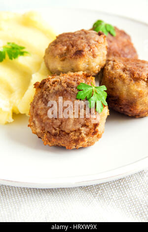 Hausgemachte gebratene Frikadellen mit Kartoffelpüree auf weißen Teller hautnah Stockfoto