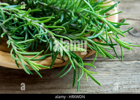 Rosmarin Blätter Haufen Nahaufnahme. Frische Bio Aroma Rosmarin-Pflanzen auf Holztisch. Gewürze, Kochen, Zutaten für eine gesunde Ernährung. Stockfoto