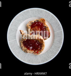 Platte mit zwei heißen gerösteten Laugenstangen mit Marmelade auf einem schwarzen Hintergrund Stockfoto