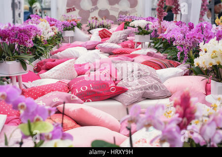 Bett mit Kissen zwischen den Orchideen. Stockfoto