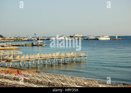 Sonnenliegen am späten Nachmittag an einem leeren Strand von Juan Les Pins, Côte d ' Azur Stockfoto