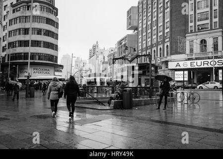 Madrid, Spanien - 20 November, 2016: Regentag in der Gran Via in Madrid. unbekannte Menschen zu Fuß unter dem Zug. schwarz-weiß-Bild Stockfoto