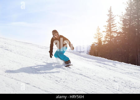 Snowboard Winteraktivitäten, Snowboarder bergab am Hang in Bergen Stockfoto