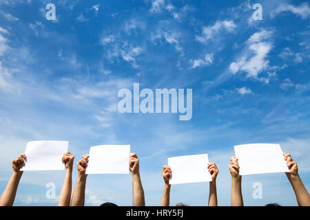 Gruppe von Menschen halten leer Blankopapier Zeichen auf blauem Himmelshintergrund Stockfoto