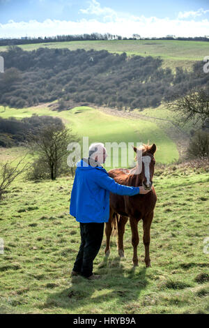 Nigel Higson, eine freiwillige "Lookerer", während eine tägliche Check-up auf sieben New Forest Ponys, die in diesem Monat von Brighton Rat auf Downland in Orde eingeführt Stockfoto