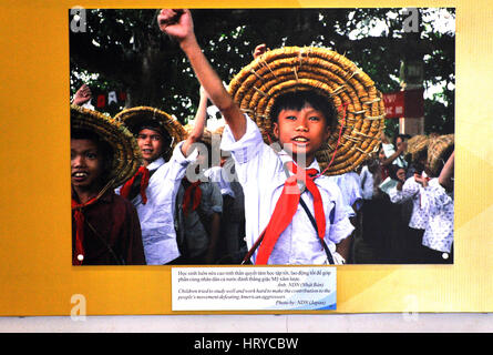 HO CHI MINH - 7. März: Propaganda-Foto von vietnamesische Kinder feiert den 40. Jahrestag der kommunistischen Partei, in der War Remnants Museum. Auf Stockfoto