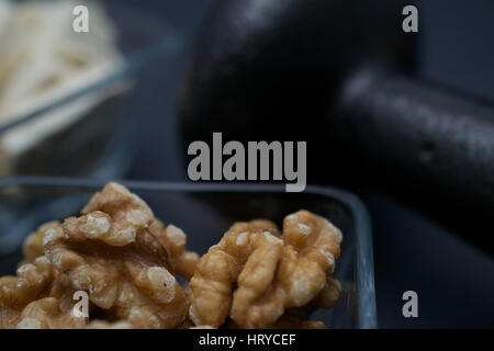 Closeup auf Hantel, Walnüsse und Tofu auf dunklem Hintergrund: Fitness und Gewicht-Verlust-Konzept. Stockfoto