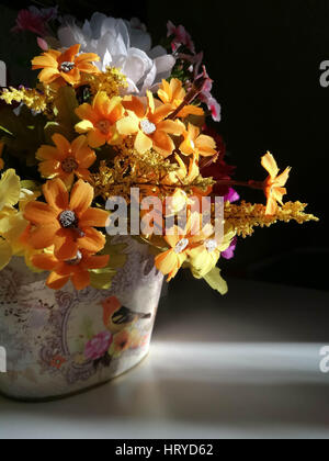 Blumen in einer Vase in einem dunklen Zimmer Stockfoto