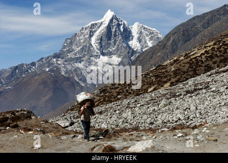 Schwer beladene Träger Klettern, Chukkung Dorf in der Khumbu-Region von Nepal Stockfoto