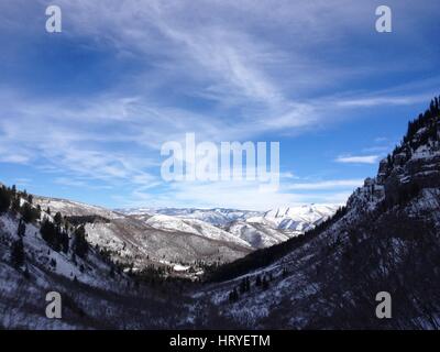 Wispy Wolken und Blues Himmel über verschneiten tief Wasatch Berge in Utah County. Blick hinunter in Richtung Sundance und Provo Canyon auf einem Winternachmittag Stockfoto