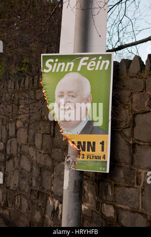 Falls Road, Belfast, UK. 5. März 2017. Ein Wahlplakat der Sinn Féin brennt. FRA McCann Plakat wurde in der Falls Road in Belfast angezündet. Heißen Kunststoff Emebers Tropf vom Plakat. Bildnachweis: Bonzo/Alamy Live-Nachrichten Stockfoto