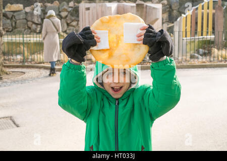 Sieben Jahre alter Junge hält einen Lángos, einem ungarischen Tiefe gebratenes Fladenbrot. Wien, Österreich, Europa. Stockfoto