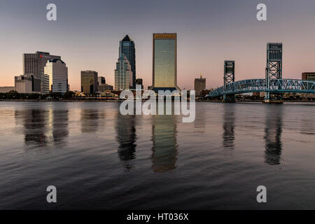 Die Skyline der Stadt vom Southbank Riverwalk entlang der St. Johns River bei Sonnenuntergang in Jacksonville, Florida. Stockfoto