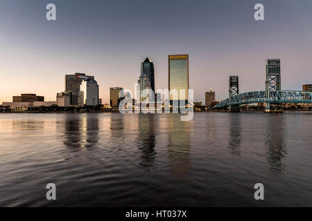 Die Skyline der Stadt vom Southbank Riverwalk entlang der St. Johns River bei Sonnenuntergang in Jacksonville, Florida. Stockfoto