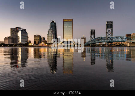 Die Skyline der Stadt vom Southbank Riverwalk entlang der St. Johns River bei Sonnenuntergang in Jacksonville, Florida. Stockfoto