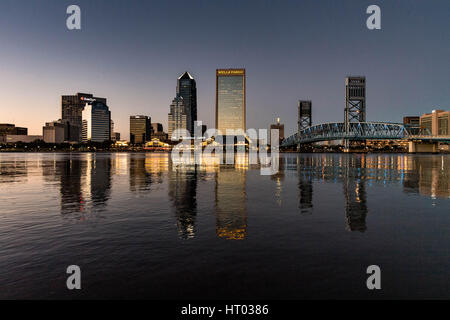 Die Skyline der Stadt vom Southbank Riverwalk entlang der St. Johns River bei Sonnenuntergang in Jacksonville, Florida. Stockfoto