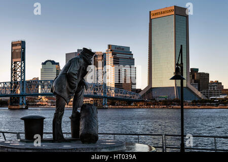 Die Lone Sailor Statue und Stadt Skyline von Southbank Riverwalk entlang der St. Johns River bei Sonnenuntergang in Jacksonville, Florida. Stockfoto