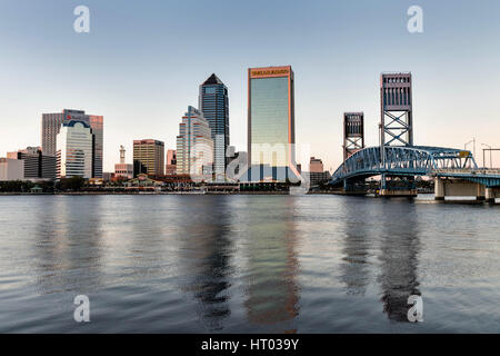 Die Skyline der Stadt vom Southbank Riverwalk entlang der St. Johns River bei Sonnenuntergang in Jacksonville, Florida. Stockfoto