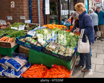 Shopper kaufen Obst und Gemüse aus einem äußeren Display in einem Obst-und Gemüsehändler Shop in Northallerton North Yorkshire England UK 2017 Preise Stockfoto