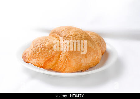 Croissant auf kleinen Teller o weißer Hintergrund Stockfoto