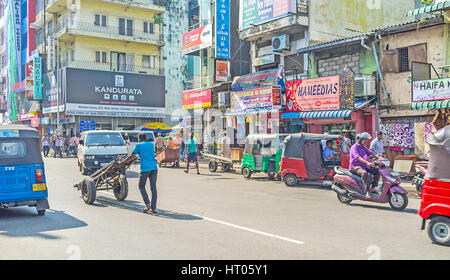 COLOMBO, SRI LANKA - 6. Dezember 2016: dem chaotischen Verkehr in der Main Street von Pettah, Tuk-Tuks, Portier mit Trolley und Autos bewegen sich in verschiedenen directio Stockfoto