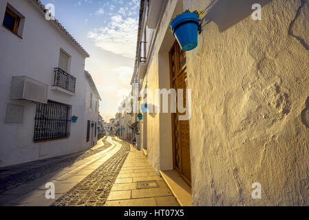 Straße mit typischen Blumentöpfe bei Sonnenuntergang in Mijas. Andalusien, Spanien Stockfoto