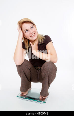 Froehliche Frau Auf Waage - glückliche Frau im Maßstab Stockfoto