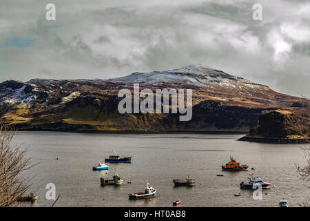 Ben Tianavaig und Sound of Raasay durch den Hafen von Portree, auf der Isle Of Skye, Schottland, gegen einen dramatischen Himmel Stockfoto