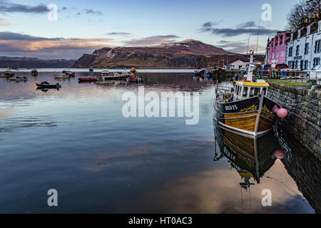 Fischerboot im Hafen von Portree, vor farbigen Häusern, mit Reflexion im Meer Stockfoto