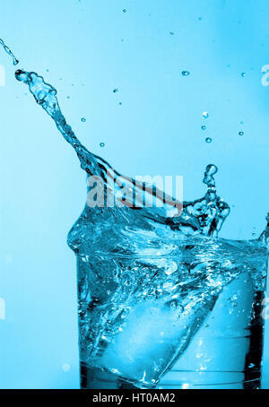 Eisw? Rfel f? Llt in Wasserglas - Eiswürfel fällt ins Wasserglas Stockfoto