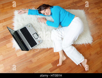 Junge Frau Liegt Wohnhauses Neben Laptop bin Fu? Boden - junge Frau Relxing auf dem Boden Stockfoto