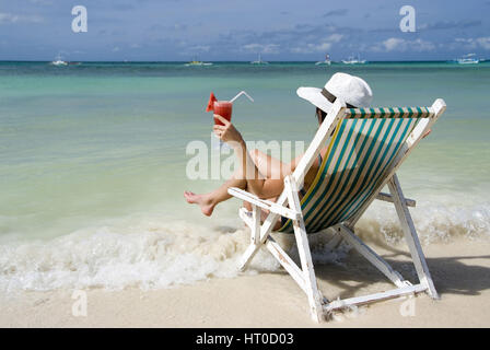 Frau Auf Klappstuhl Genie? t Cocktail ein Meeresufer - Frau mit Cocktail genießt Urlaub auf See Stockfoto