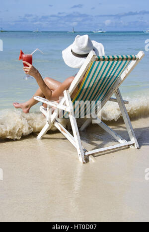 Frau Auf Klappstuhl Genie? t Cocktail ein Meeresufer - Frau mit Cocktail genießt Urlaub auf See Stockfoto