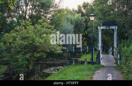 Eine kleine Fußgängerbrücke über einen Kanal in einem Wohngebiet von Zaandam, Niederlande. Stockfoto